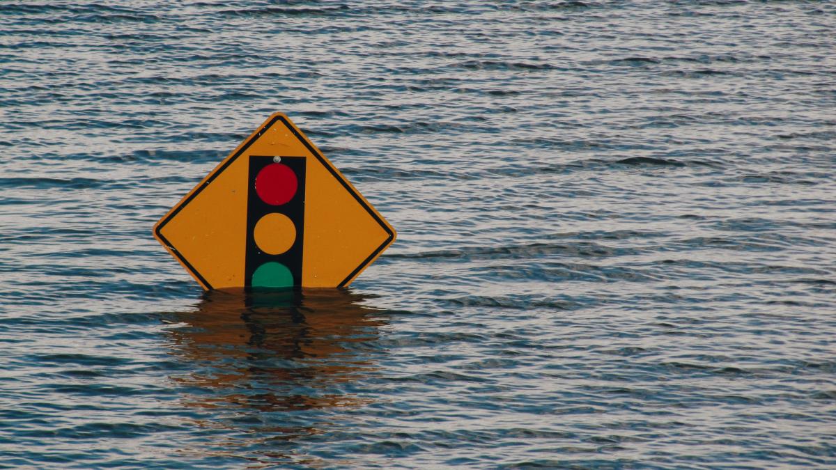 A traffic sign is partially submerged in flood waters.
