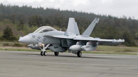 A US Navy Growler aircraft lands on a runway on Whidbey Island.