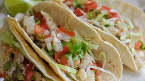 A serving of fish tacos with fresh vegetables.