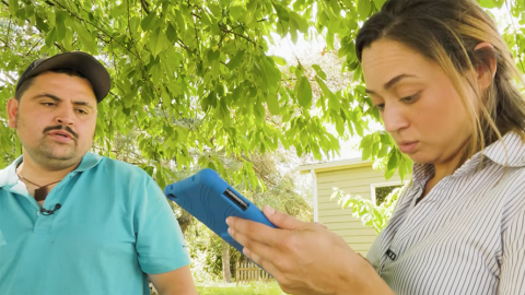 Photo of female researcher interviewing a male farmworker, using tablet device.