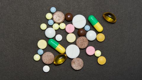 A variety of opioid pills on a black background.