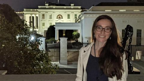 Rachel Shaffer stands in front of the White House in the evening.