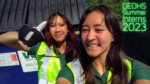 Kai and Allison smiling at the camera in high vis vests with the DEOHS Summer Jobs logo on it.