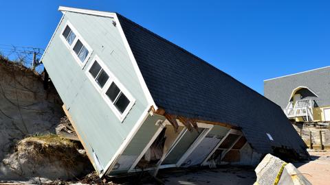 A house damaged by Hurricane Irma sits on its side after sliding down a cliff.