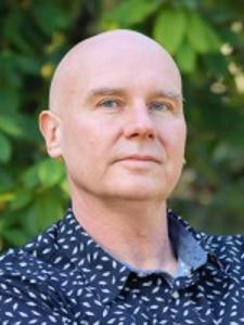 Dr Gill, a middle-aged bald white man wearing a patterned shirt