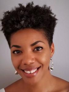Woman with short curly black hair and silver earrings