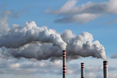Smokestacks with exhaust rising into the sky.