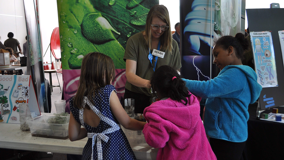 Petroff interacting with schoolchildren at a demonstration table at the Pacific Science Center.