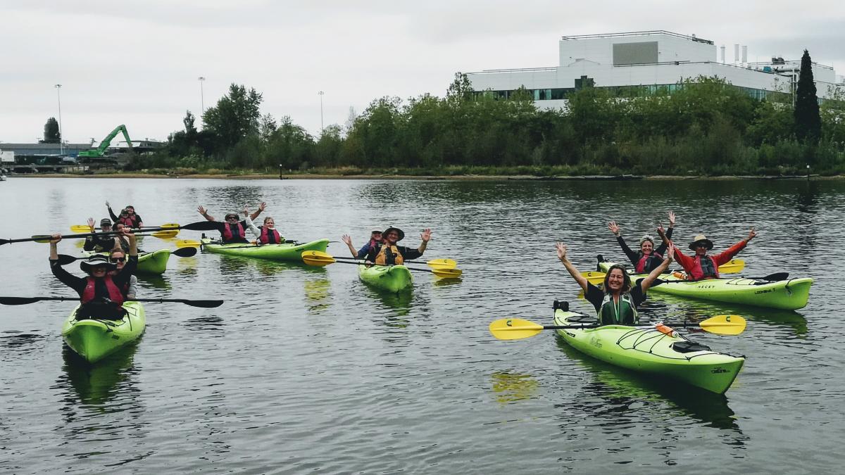 kayakers hold up their paddles