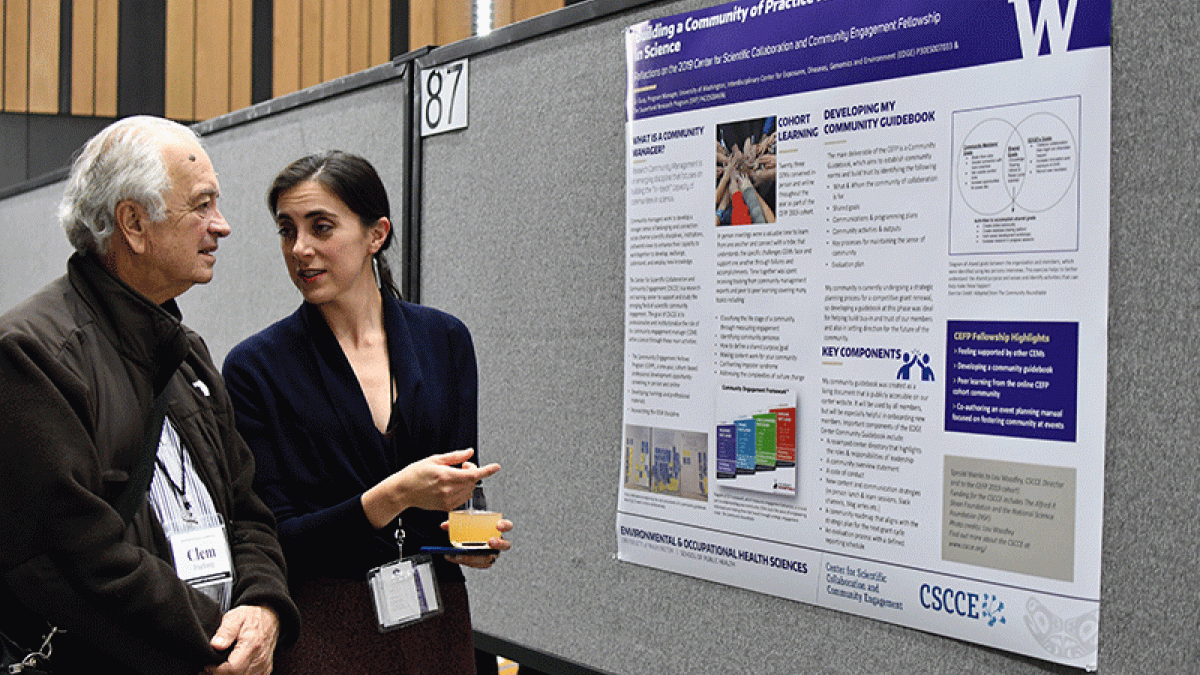 Liz Guzy talks to Clement Furlong in front of a research poster